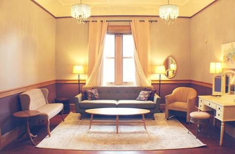 The Bridal Suite, a cozy lounge with a mirror, sofa, and reading lamps