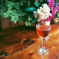 A cocktail and fresh flowers on en Rama's wood bar