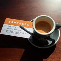 A shot of espresso beside a Lift Bridge Coffee card